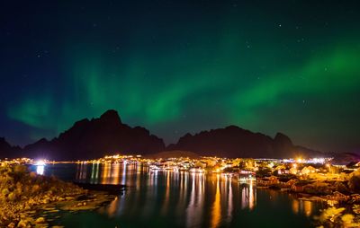 Scenic view of illuminated sea against sky at night