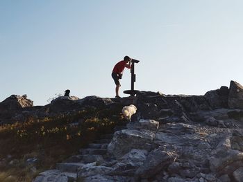 Man standing on rock against clear sky