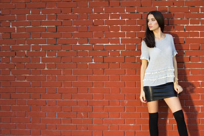 Woman standing against brick wall