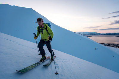 Man backcountry skiing in iceland at sunrise
