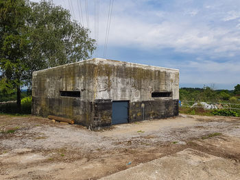 Abandoned building on field against sky