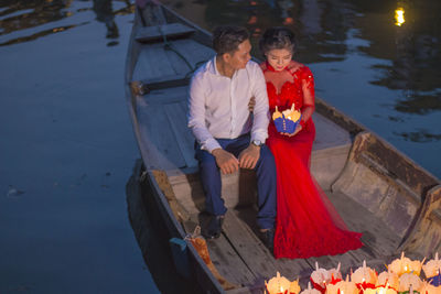 Couple holding a boat in water