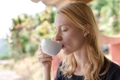 Woman drinking coffee outdoors