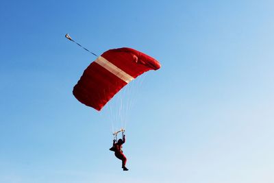 Low angle view of person paragliding against sky