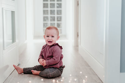 Portrait of cute girl sitting on floor at home