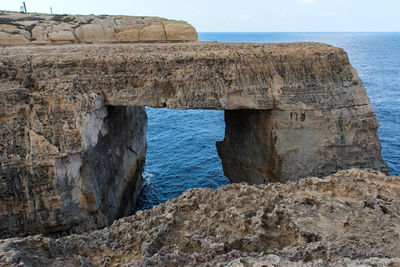 Wied il mielah canyon and natural arch over the sea in gozo, malta