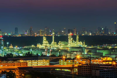 High angle view of illuminated buildings against sky at night oil refinery