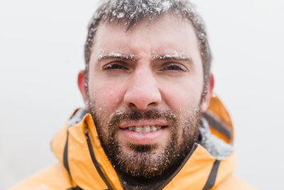 Close-up portrait of smiling man in snow