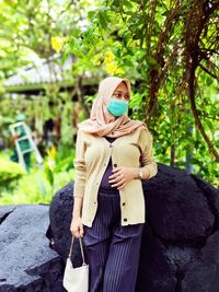 Woman standing against plants