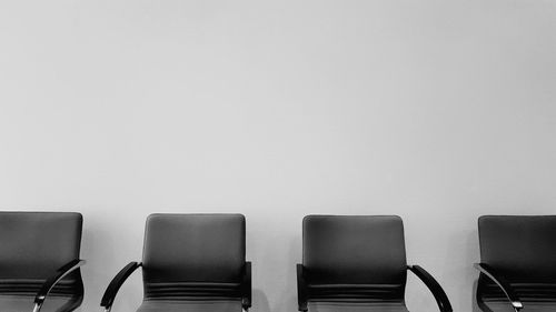 Empty chairs against white background