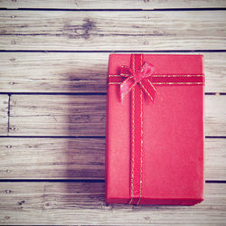 Close-up of red wrapped gift on wooden table