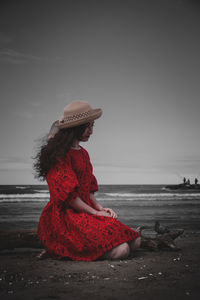 Woman looking at sea against sky