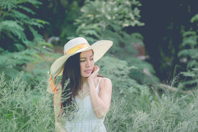 Young woman wearing hat standing on field