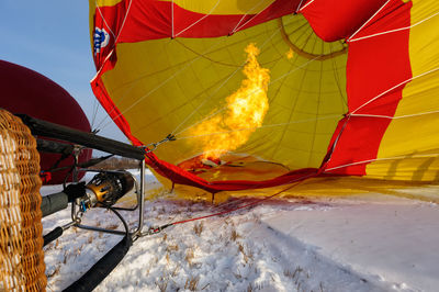 Fire inflating hot air balloon on snow