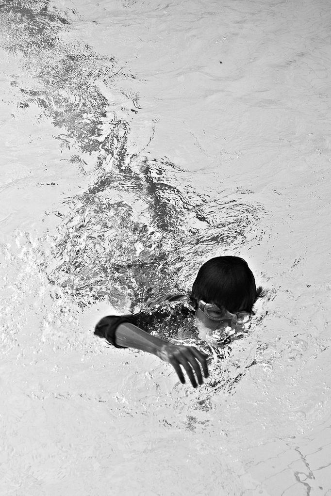 HIGH ANGLE VIEW OF WOMAN SWIMMING UNDERWATER IN POOL