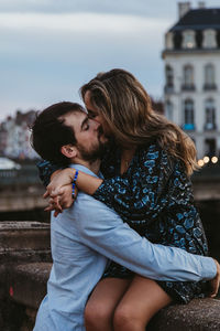 Young couple kissing against blurred background