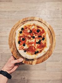 High angle view of hand holding pizza