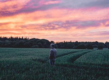 Man on field against sky during sunset