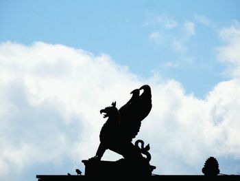 Low angle view of griffin statue on roof against sky at krestovsky island