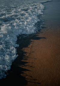 High angle view of waves rushing towards shore