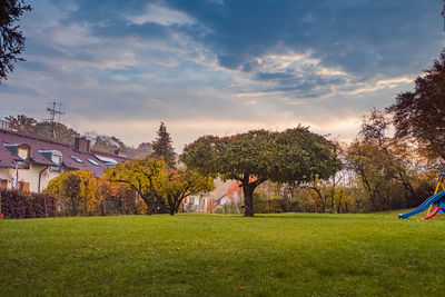 Trees in park against cloudy sky