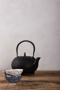 Close-up of tea cup on table against wall