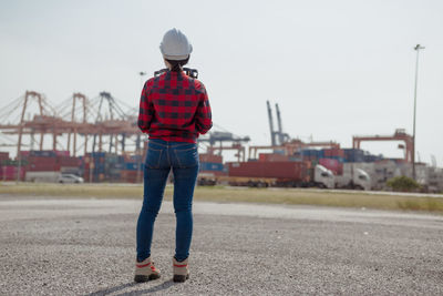 Rear view of man standing on street against sky