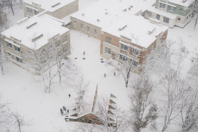 High angle view of snowy street and playing kids
