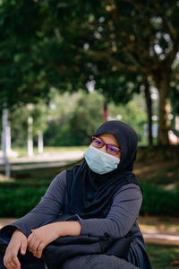 Young muslim woman wearing glasses and hijab head scarf and face mask. casual girl in outdoor.