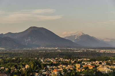 Aerial view of townscape and mountains against sky