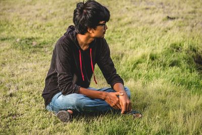 Young man looking away on field