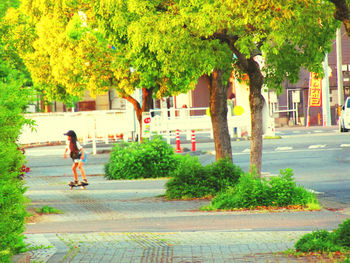 Man walking on footpath by street in city