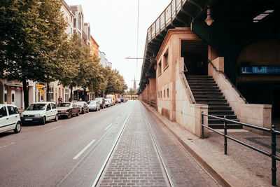 Empty road amidst buildings in city