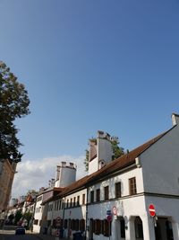 Low angle view of buildings against clear blue sky