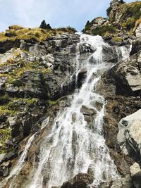 Scenic view of waterfall against sky