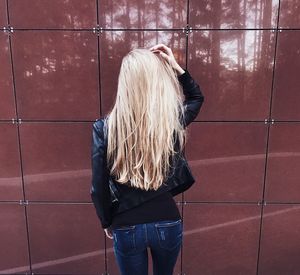 Rear view of woman standing against wall