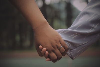 Close-up of couple holding hands