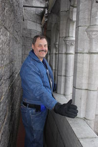 Portrait of smiling man standing at historic building