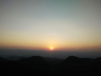 Scenic view of silhouette mountains against sky during sunset