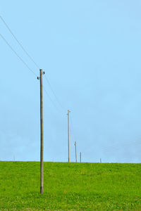 Wind turbines on field against clear sky