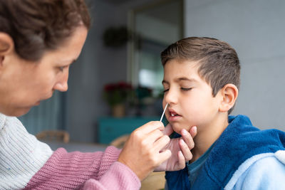 Mother doing an antigen test to her son at home