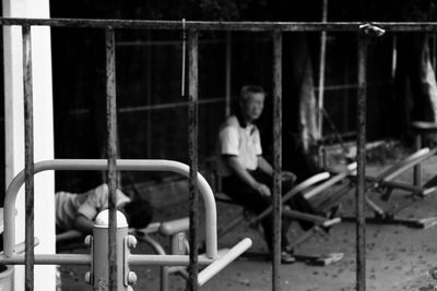 Close-up of people sitting on wall