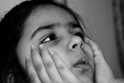 Close-up of girl with hands on chin at home