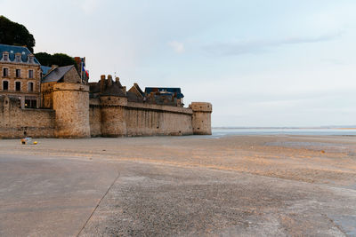 Historic building by sea against sky