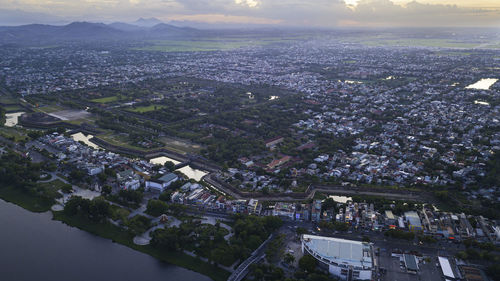 High angle view of city by river against sky