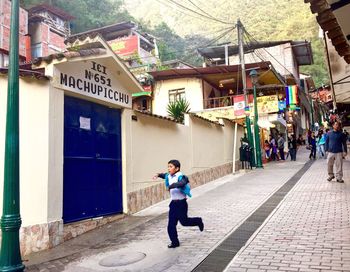 Man walking on street amidst buildings in city