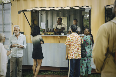 Male and female customers buying food at food truck