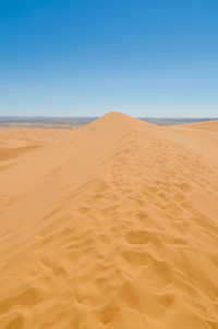 Scenic view of desert against clear blue sky