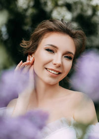 Beautiful bride in a wedding dress walks in a blooming apple-tree park in spring