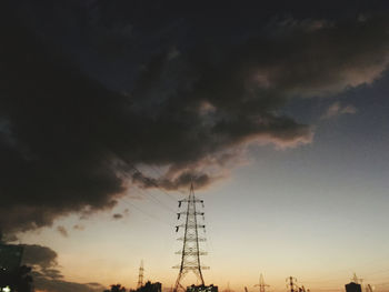 Low angle view of silhouette electricity pylon against sky during sunset